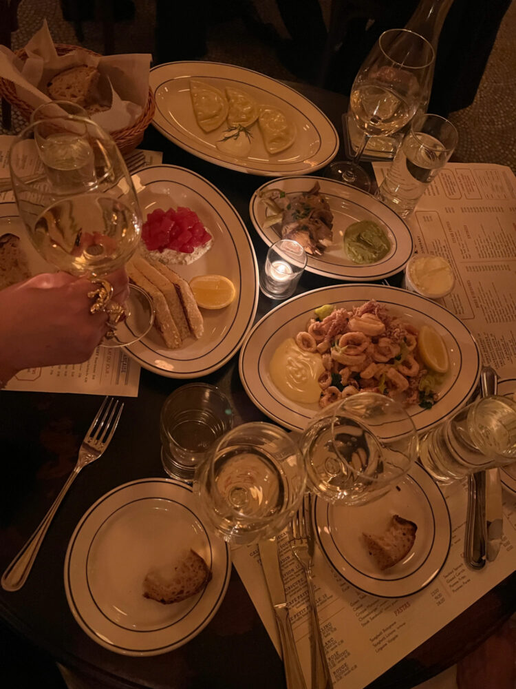 a table at Pastis DC loaded with appetizers including tuna tartare, calamari, pierogies, and artichokes