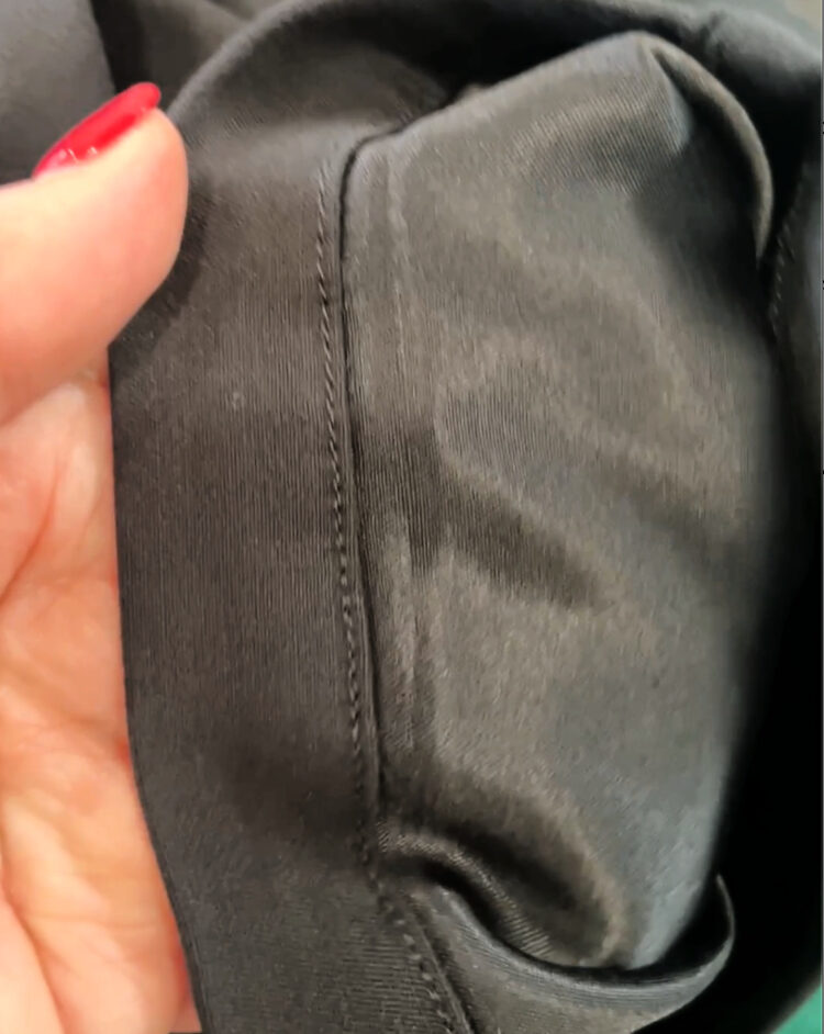 the inside of a pair of pants from Universal Standard showing the one-layer fabric is traditional suiting fabric on on side but a satin on the other.