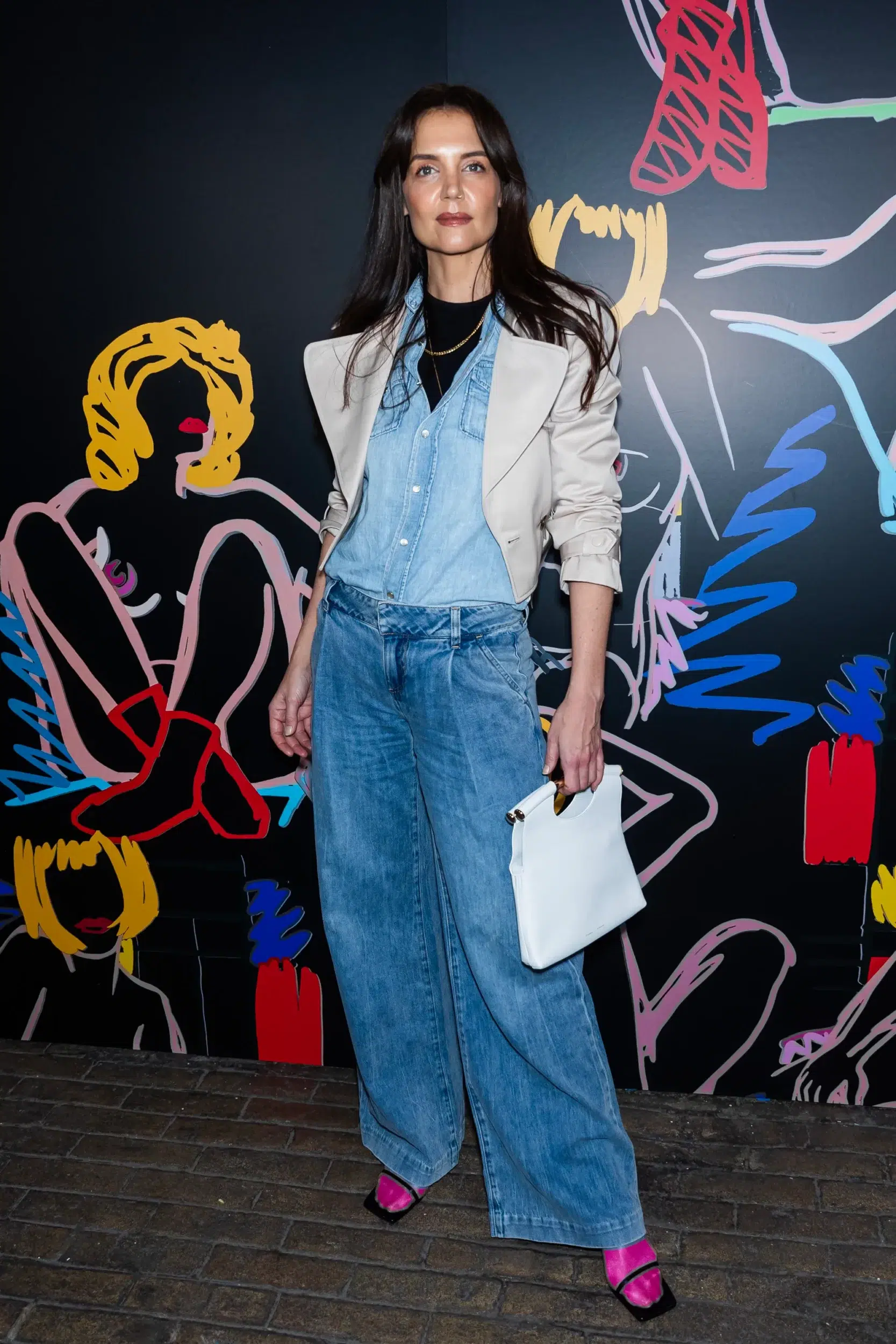 Actress Katie Holmes wearing a denim shirt, denim jeans, and hot pink socks with heels