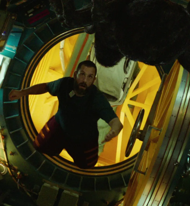 Adam Sandler moving through his spacecraft in the 2024 film Spaceman