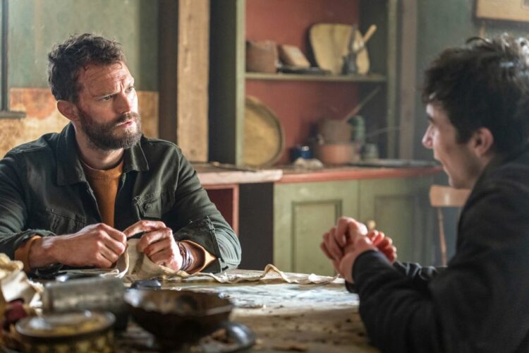 Jamie Dornan sits at a dining table in the second season of the tourist on netflix