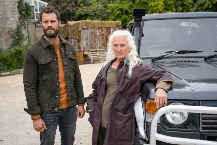 The character Elliott and his mother, Niamh in season 2 of The Tourist. They are standing outside a house, Niamh leaning against a Jeep.
