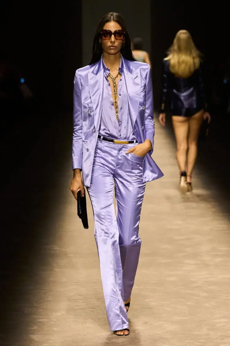 A look from Tom Ford's Spring/Summer 2024 runway collection featuring a lilac satin pantsuit with a lilac blouse