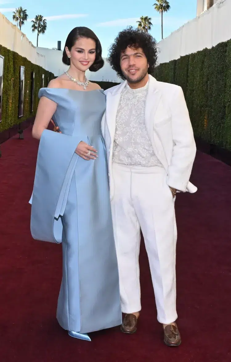 Selena Gomez and Benny Blanco in Beverly Hills in January 2025 at an awards show. Selena is in a blue evening gown and Benny is in a white tuxedo.