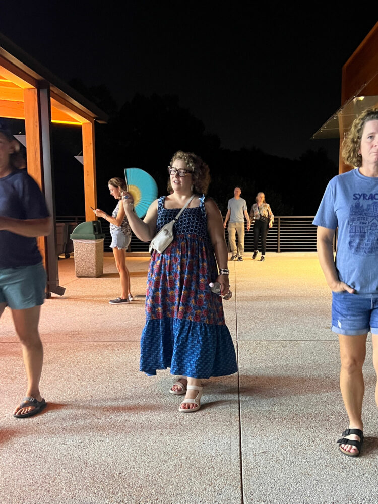 alison gary in a floral maxi dress styled with teva hurricane drift sandals