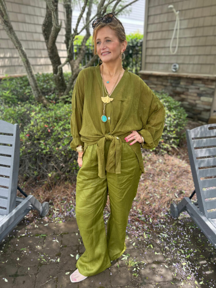 Woman in an olive green gauze shirt and matching pants from Monday Swimwear