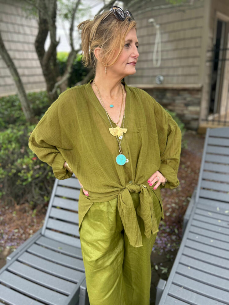 Woman in an olive green gauze shirt and matching pants from Monday Swimwear