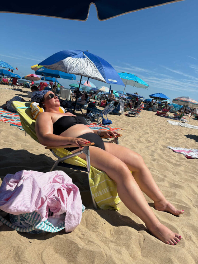 Woman lying on the beach in a black bikini