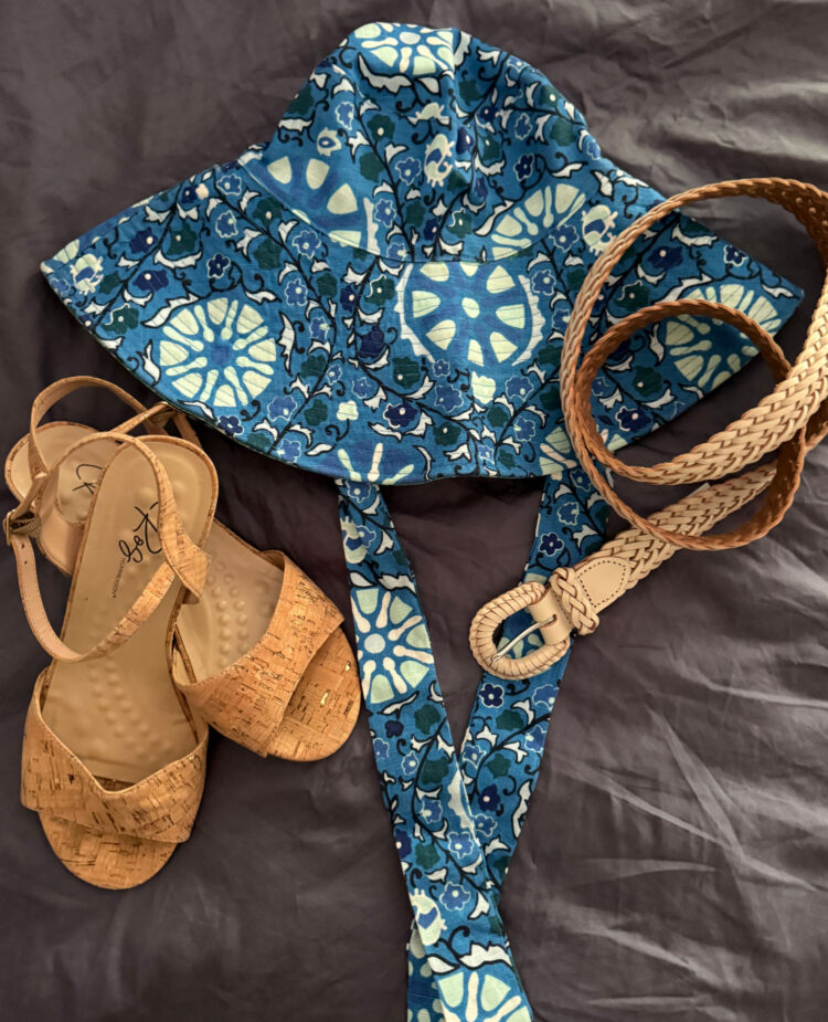a blue print cotton sunhat, a white leather braided belt, and a pair of cork Ros Hommerson sandals 