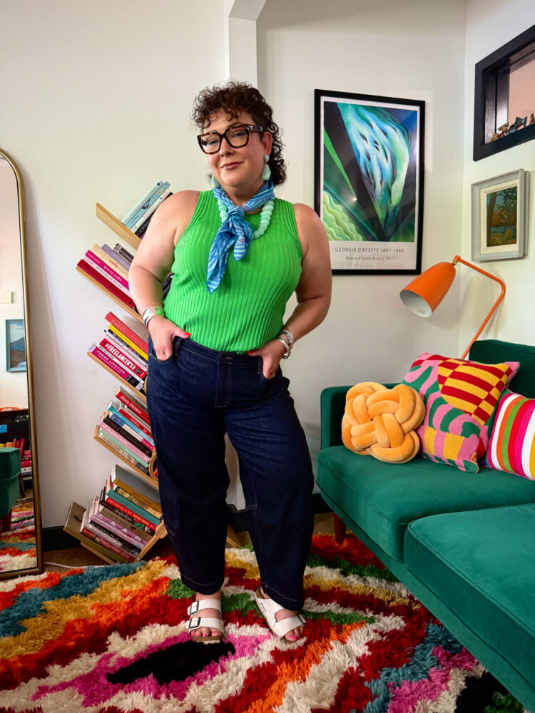 wardrobe oxygen wearing a green universal standard sleeveless sweater tucked into ruti barrel jeans