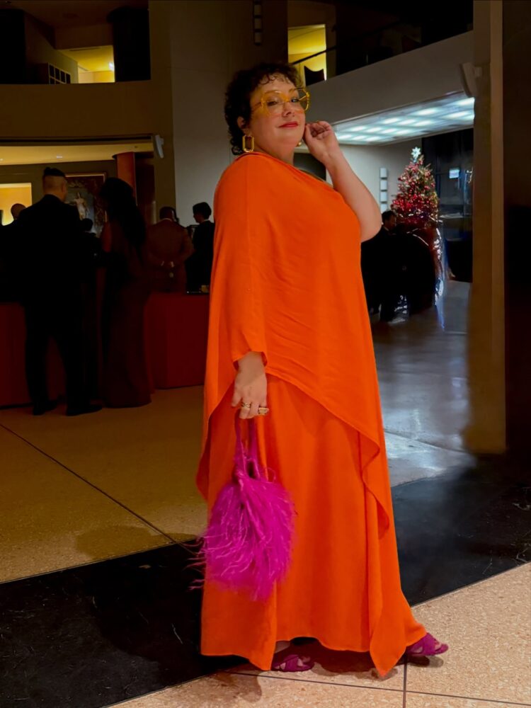 Over 40: What to Wear to a Black Tie Occasion 5 Alison Gary of Wardrobe Oxygen, a 50-year-old midsized woman in an orange silk chiffon one shouldered gown, holding a hot pink feather purse at a gala at the Italian Embassy