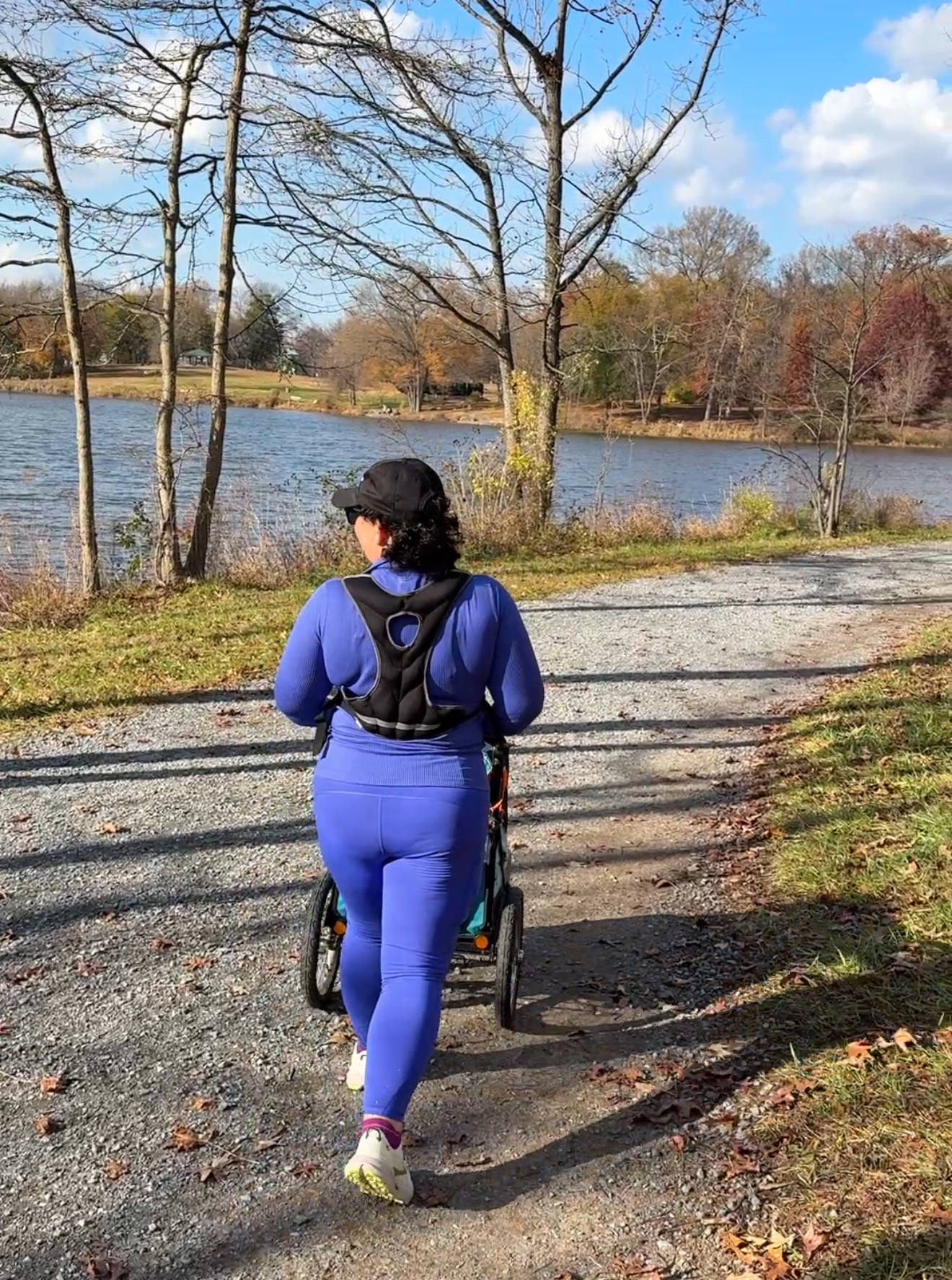 Alison walking next to a lake in Athleta Borealis flurry top and rainier leggings