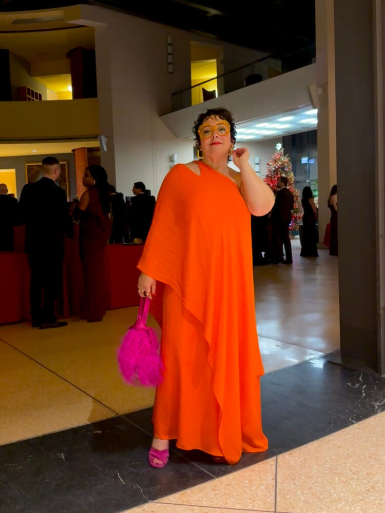 What I Wore to an Embassy Gala 5 what I wore to an embassy gala as a 50 year old plus size woman: alison gary of wardrobe oxygen in an orange one shouldered caftan gown and hot pink feather bag from J. Crew