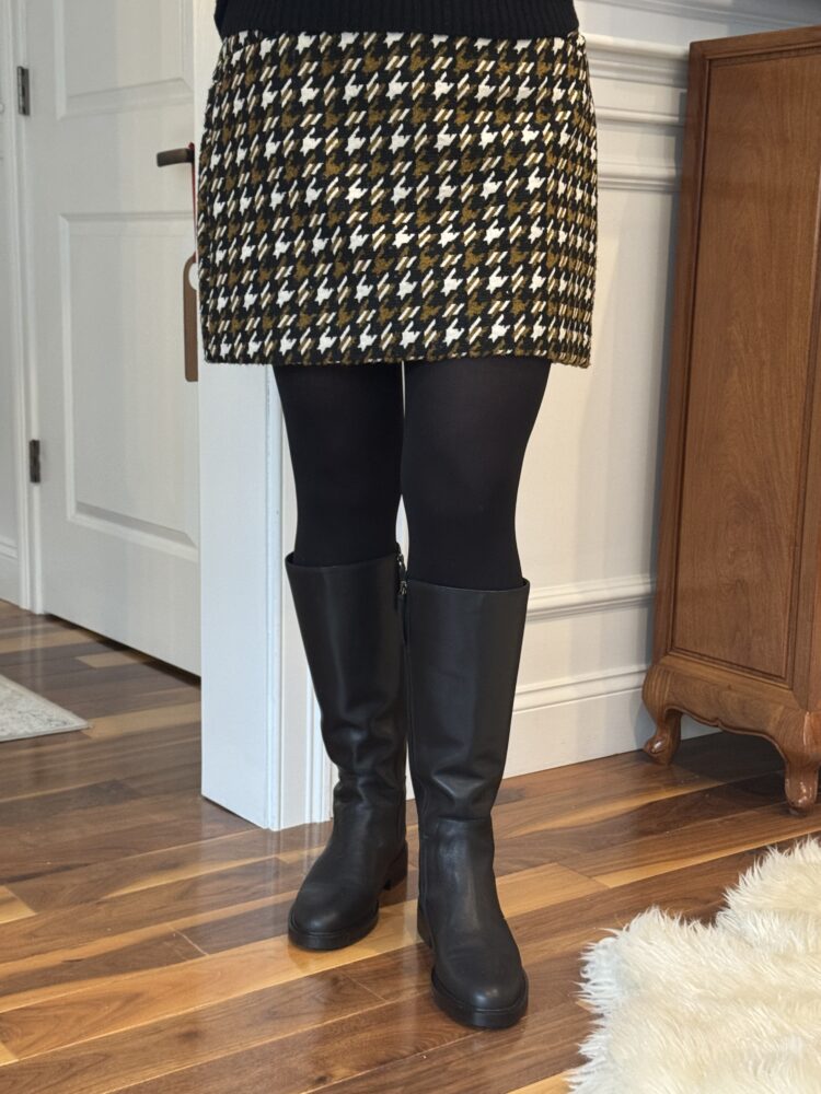 Quince Shoes Review: Italian Leather Boots, Loafers, and Flats Tested by a Real Woman in Her 50s 3 review of quince tall riding boots as seen on an over 50 woman styled with black tights and a plaid knee-length skirt for wardrobe oxygen