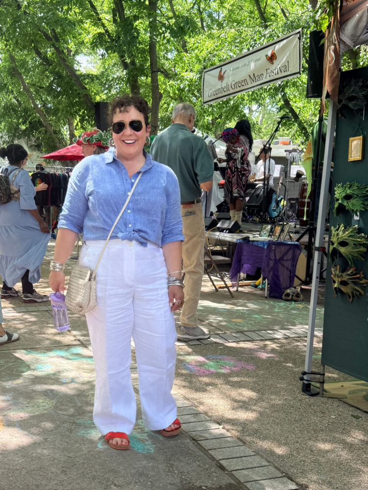 Talbots Linen Review (and how to save 30% on your purchase) 4 Detail of the Talbots Linen Everyday Relaxed Shirt in cornflower blue cross dye tied at the waist, worn at an outdoor festival.