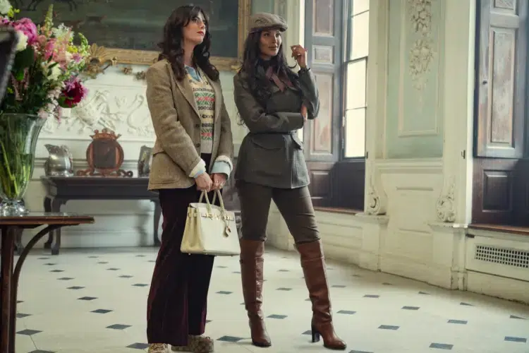 Weekend Reads for the End of September 5 "Two stylish women stand in an elegant, classic interior with tall windows and ornate decor. One holds a white handbag, both wear blazers and boots, appearing poised and fashionable in a well-lit, sophisticated room with flowers and art."