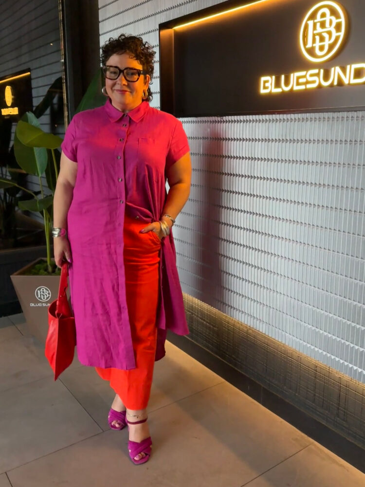 alison gary of wardrobe oxygen in a universal standard linen shirtdress with spanx cropped petite kick flare pants in a combination of hot pink and orange